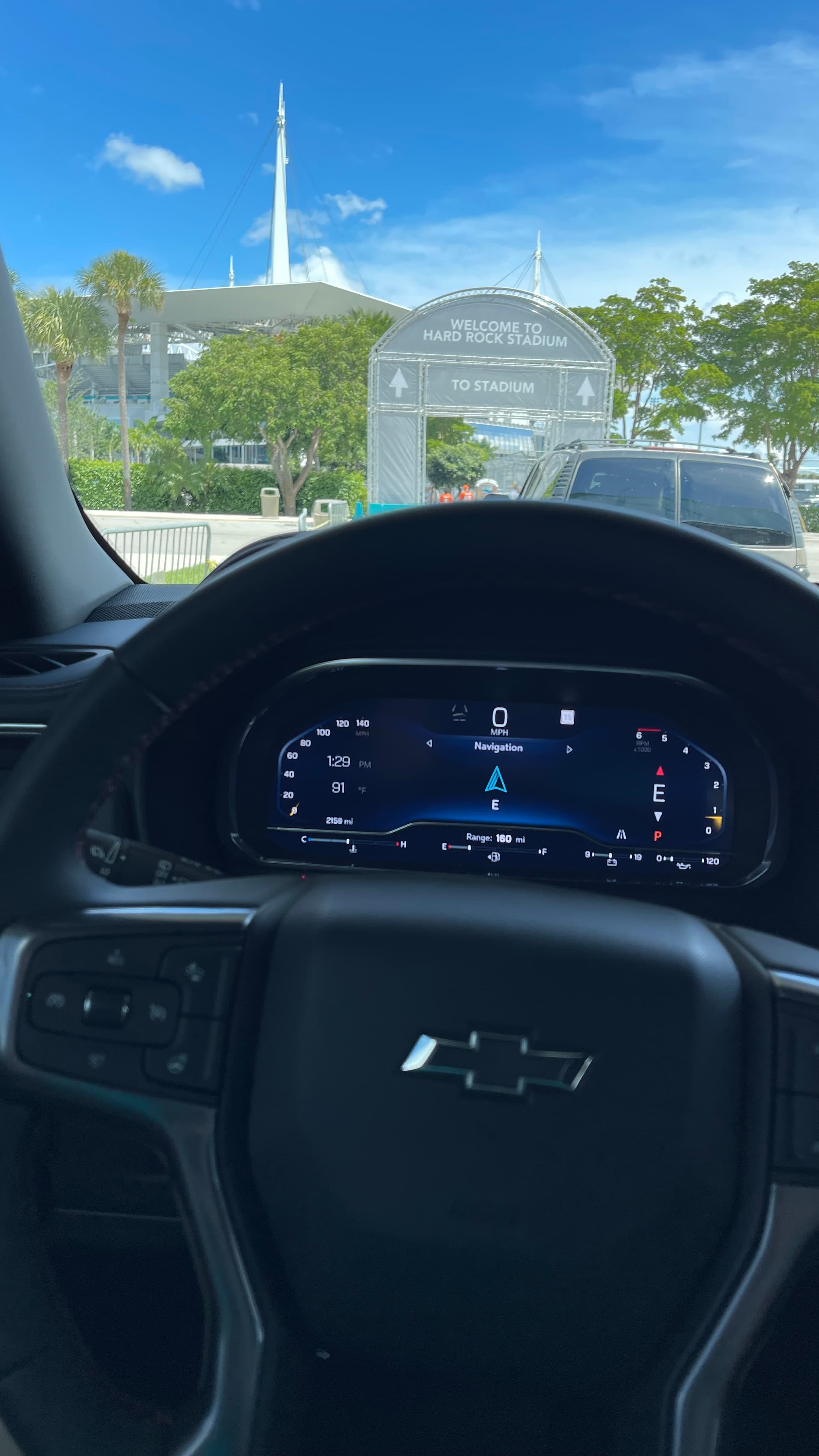 Driver's-eye view through a Suburban windshield, Hard Rock Stadium on the horizon